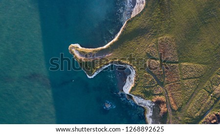 Aerial views of the dynamic chalk cliffs showing coastal erosion on the purbeck coastlines of England. The specific location is called Old Harry Rocks. Royalty-Free Stock Photo #1268892625