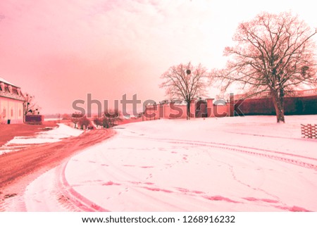 A beautiful winter landscape with old-fashioned buildings covered with snow, without people, winter landscape, and a light on the fence and sunset, a new morning of winter.Vintage colors picture. 