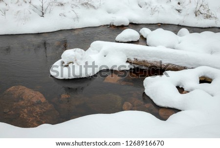 Winter river under the snow and ice