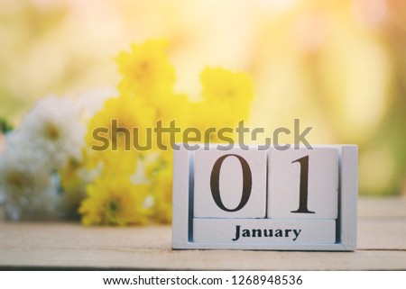 close up wooden calendar and beautiful flower on old wood table, 1 january, nature wallpaper background, countdown to holiday season, happy new year 2019 concept, vintage tone