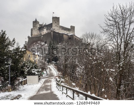 The beautiful night view of Festungsberg mountain, with majestic Hohensalzburg Fortress in the background and leading road in the foreground captured in winter. Salzburg, Austria