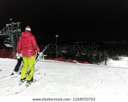 stylish alpine skier at night ski track
