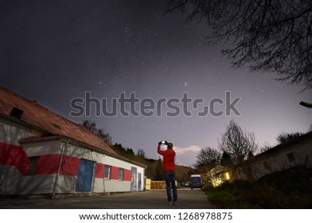 Sky full of stars and a boy photographing stars with his mobile phone