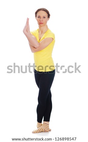 Young woman doing yoga exercise on a white background.