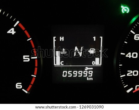 Car speedometer and counter with dark mode.Display showing the empty gear position and distance 59999 kilometer reminders to auto car center.