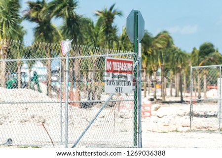 No trespassing, designated construction site warning sign attached to fence gate in Florida,  