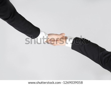 Close up top view of two Asian business men in suit and white shirt, black shoes, standing and handshaking on business agreement, on white isolated background
