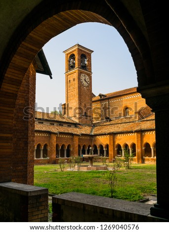 The clock tower of the Chiaravalle abbey, near to Milan, looking through an arch