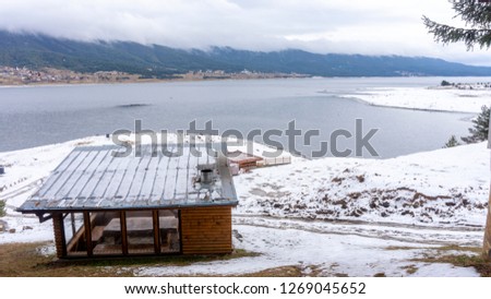 Photo of random cozy wooden-stone gazeboo built in village area in the forest of Rhodope mountains, with wonderful view to the clear waters of Dam Dospat, Bulgaria.