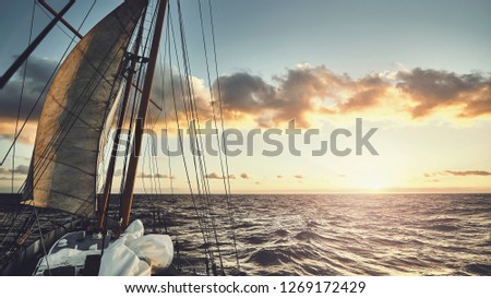 Old schooner sailing at sunset, travel and adventure concept, color toned picture.