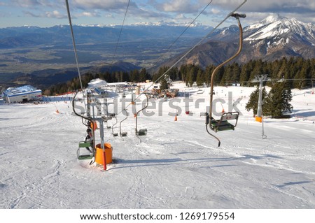 Ski lift equipment at Alpine winter skiing and wintersports resort Krvavec, Slovenia with stunning view on the valley below