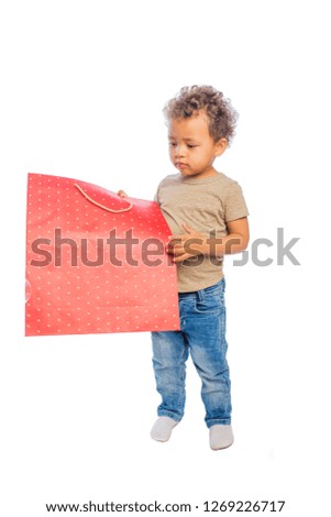 Beautiful black child looking on a large package with a gift on an isolated background