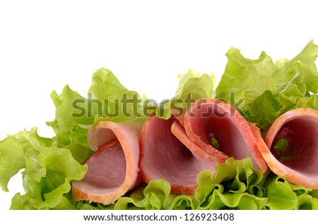 Slices of ham on green salad, isolated on a white background