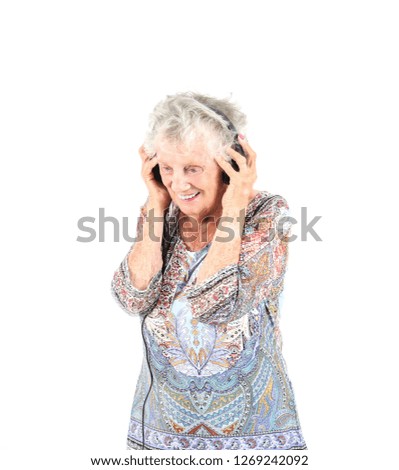 Happy old woman smiling while wearing black headphones against a white background