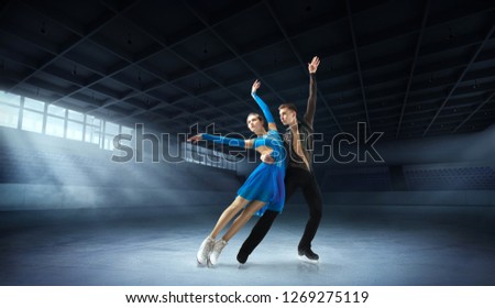 Figure skating pair in ice arena