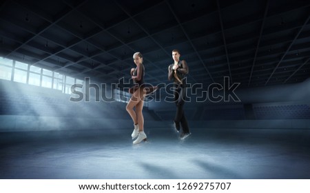 Figure skating pair in ice arena
