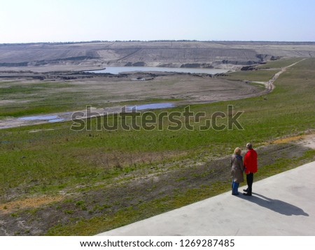 two people looking into the former lignite open pit mining area, from which the lake Großräschener See is formed by flooding - the picture was taken on 25 March 2007, 10 days after the flooding began 