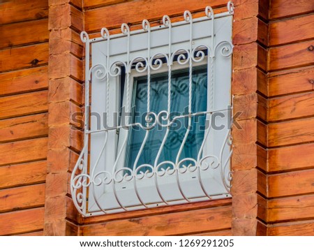 Beautiful and diverse subject. Beautiful and original view and background to an interesting wooden building and a window with bars on the nature.
