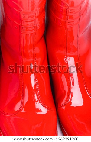 Beautiful and original look and background for interesting designer and creative decorative women's and children's boots in purple and red glossy.
