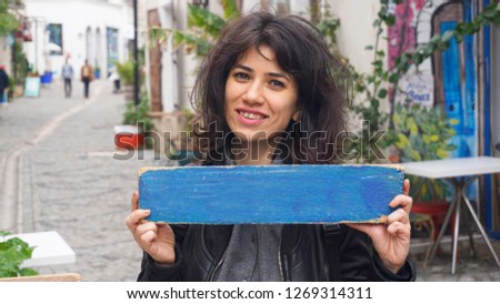 Beautiful woman holding empty sign. Girl showing blank signboard. Copy space for ad text. 