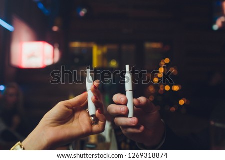 IQOS heat-not-burn tobacco product technology. Man holding e-cigarette in his hand before smoking.