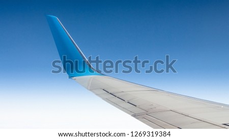 View from the window to the winglets of the civilian aircraft. Blue cloudless sky Royalty-Free Stock Photo #1269319384