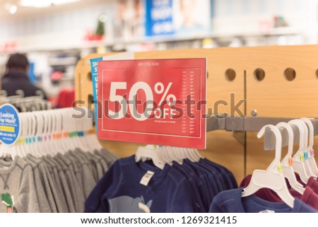 Close-up red tag sale 50 percent discount at baby clothes store in Texas, USA. Big reductions concept for Black Friday and Holiday season sale. Business fashion and advertisement