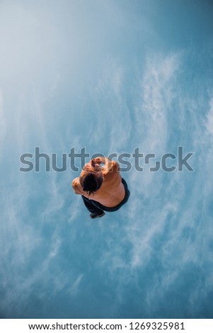 Caucasian man below blue sky make parkour jump