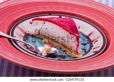 A colorful picture with cram and jello tart on a plate and striped backgound.