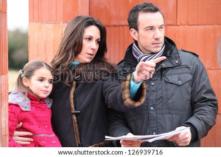 family looking at the plan of their future house