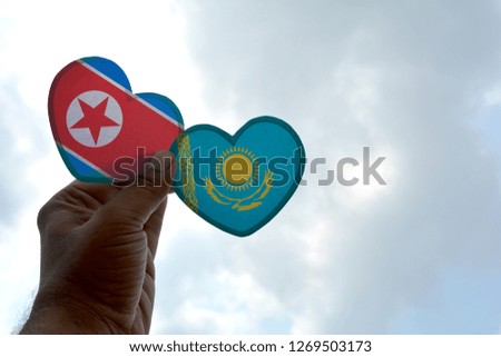 Hand holds a heart Shape North Korea and Kazakhstan flag, love between two countries
