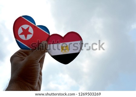 Hand holds a heart Shape North Korea and Egypt flag, love between two countries