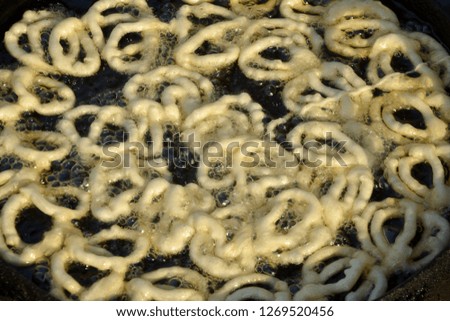 Close up of white color dough of Jalebi being fried in oil in a street shop