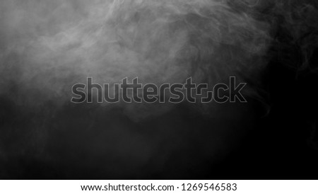 White clouds of vapor smoke are isolated on a black background. Gas explodes, swirl and dances in space. A magic fog dust texture effect that can be used by overlay and changing their transparency. Royalty-Free Stock Photo #1269546583