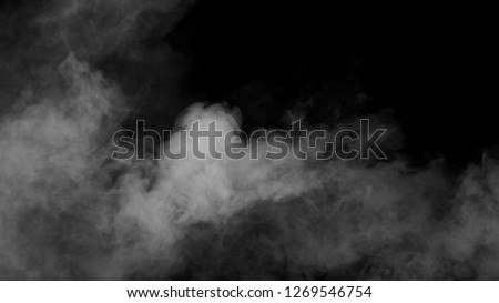 White clouds of vapor smoke are isolated on a black background. Gas explodes, swirl and dances in space. A magic fog dust texture effect that can be used by overlay and changing their transparency. Royalty-Free Stock Photo #1269546754