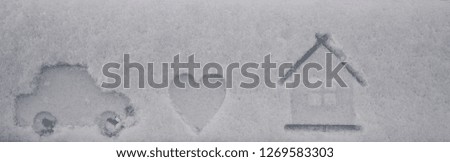 print of house, heart and car on white snow texture. winter time season background