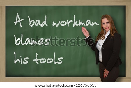 Successful, beautiful and confident woman showing A bad workman blames his tools on blackboard