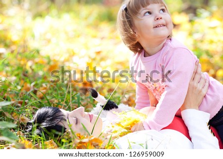 beautiful young mother and her daughter lying on the autumn leaves