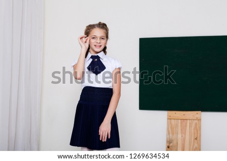 girl in glasses at the Blackboard in a class lesson 