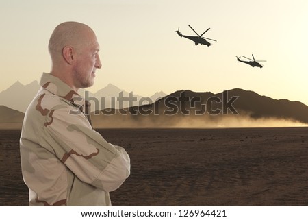 Marine amid the mountains of Afghanistan and helicopters