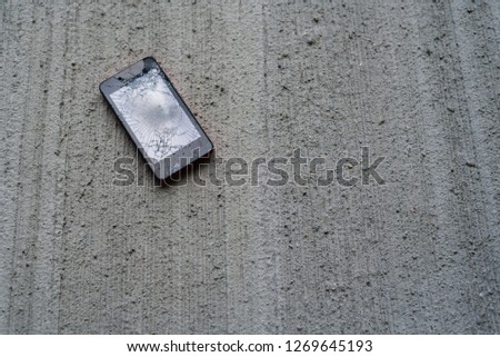 Phone with broken screen on concrete backgroung