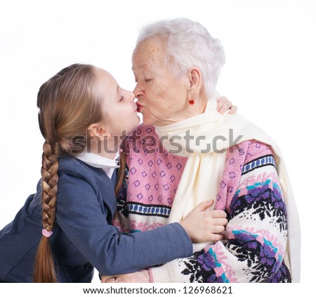 Pretty girl kissing her grandmother on a white background