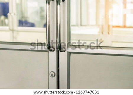 Blank glass door with metal handles. Entrance. Opened luxury hall doorway with transparent surface with shiny warm light.