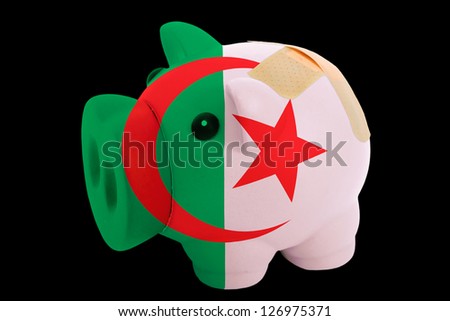 empty piggy rich bank in colors of national flag of algeria on black background