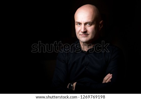 Business man posing in low key in a photo studio 
