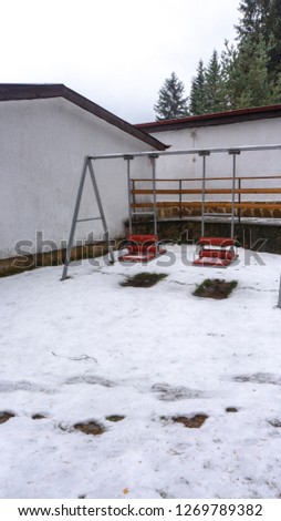 Photo of children swings in snowy area in a village complex in Rhodope mountains in Bulgaria.