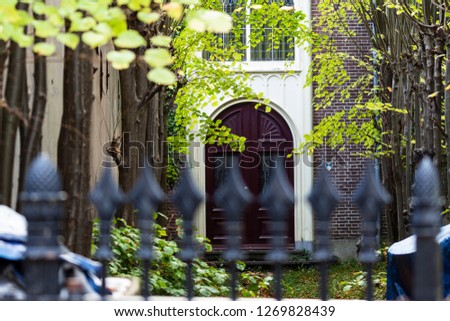 Gouda, South-Holland/The Netherlands - October 27 2018: Picture of an old house in Gouda city center shot through the front gate out of focus and the garden and entrance in focus
