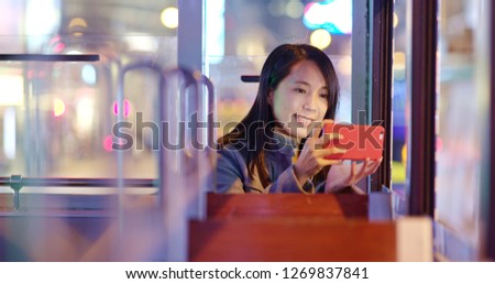 Woman take photo on tram at night