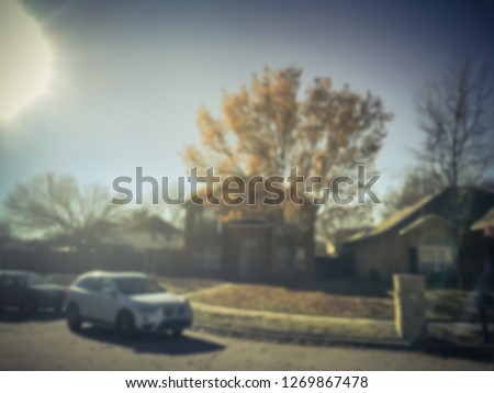 Motion blurred typical American neighborhood with row of single family houses in fall season, Texas, USA