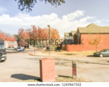 Motion blurred typical American neighborhood with row of single family houses in fall season, Texas, USA
